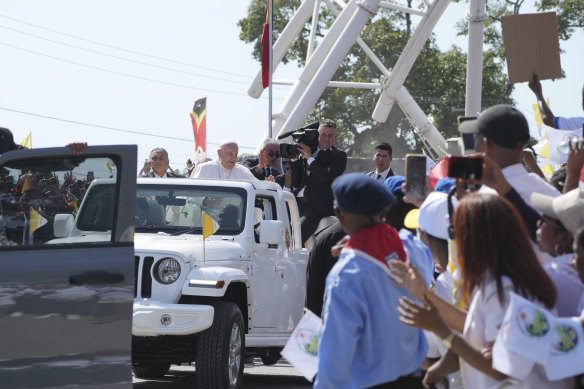 Pope Francis waves from the car upon arrival in Dili.
