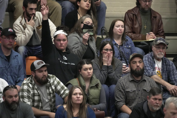 A woman raises her hand with a question during a town hall meeting at East Palestine High School, Ohio, on Wednesday.