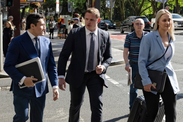 Former NRL player George Burgess (centre) arrives at Downing Centre Local Court on Monday with his lawyers Bryan Wrench and Sophie Newham.