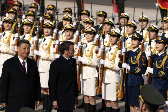 French President Emmanuel Macron, centre, inspects an honour guard with Chinese President Xi Jinping, left, outside the Great Hall of the People in Beijing, on Thursday.