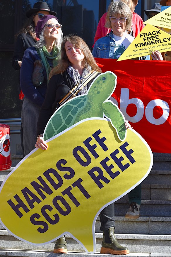 Protesters hold signs calling for the state government to keep their “hands off Scott Reef”. 