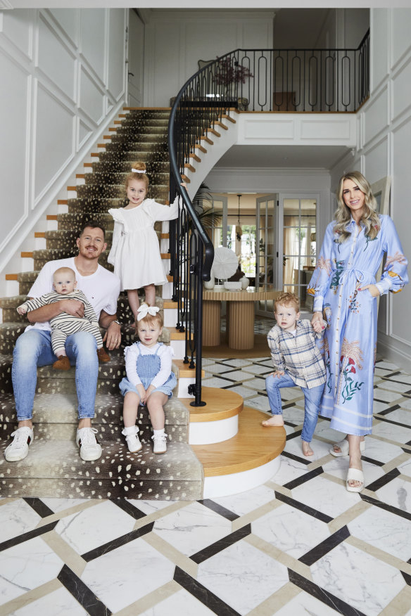 Tom Cahill, Georgia Bardoel and their young family on the staircase of their dream home.