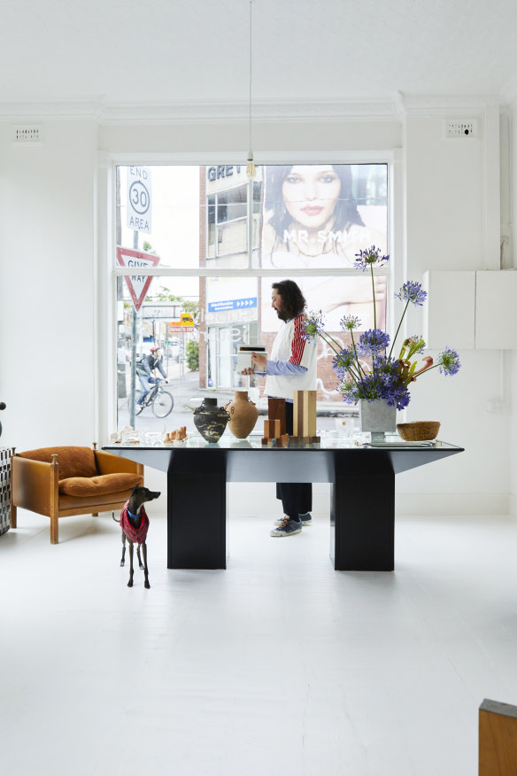 Ben Mooney with his greyhound, Goody, in the front room of his store. Local florist and designer Hattie Molloy designed the large “Ixia” vase and also created the agapanthus installation.