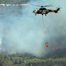 A helicopter sprays water to extinguish a fire in Seferihisar, near Izmir, Turkey.