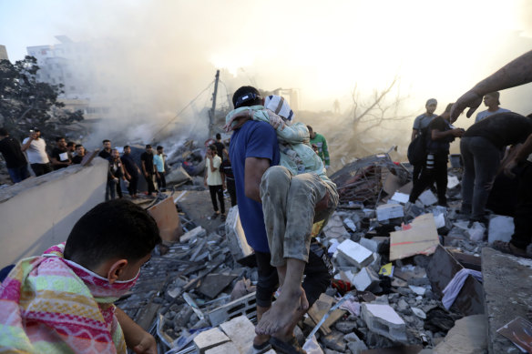 A Palestinian man evacuates a wounded girl out of the destruction following Israeli airstrikes on Gaza City.