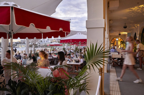 The ocean-facing terrace features red-and-white umbrellas.