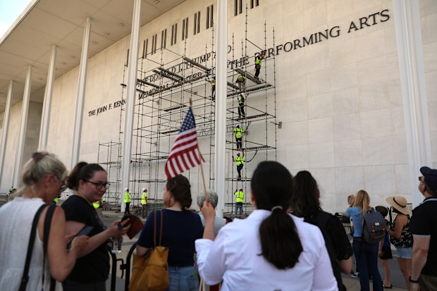 Spectators waiting to watch Donald Trump's name be taken off the Kennedy Centre.