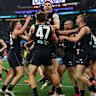 Harry Dean is swamped by teammates after kicking his first AFL goal.