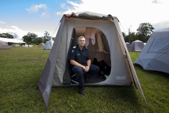 Victoria Police Acting Senior Sergeant Colin Shepherd who was deployed from the Bass Coast sits in his tent at Cann River on Wednesday.