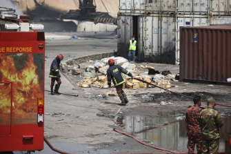 A firefighter pulls a hose at the BM Inland Container Depot where a fire broke out.