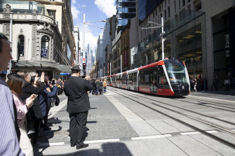 Onlookers were captivated by one of Sydney's new trams travelling along George Street for the first time during the day.