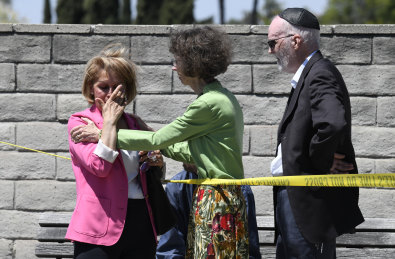 Worshipers console one another outside of the Chabad of Poway Synagogue.