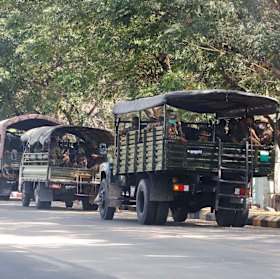 Soldiers sit inside trucks parked on a road in Naypyitaw, Myanmar, 