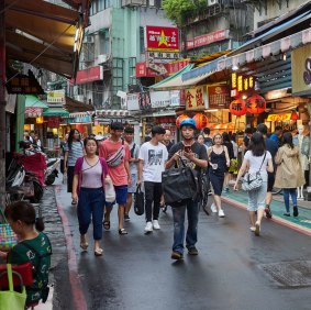 Tourists and locals walk around a night market in Taipei.  Polls consistently show that young Taiwanese in particular, have no interest in reunification with China.