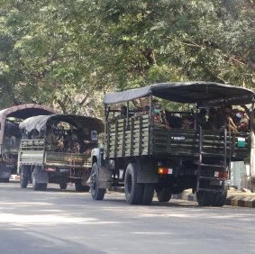 Soldiers sit inside trucks parked on a road in Naypyitaw, Myanmar, 