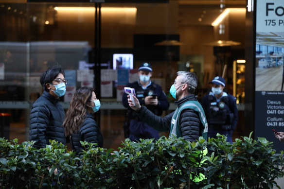 People queuing for the new mass vaccination hub in Sydney’s CBD have their temperature checked on Monday morning. 
