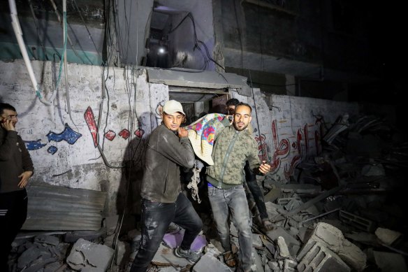 Palestinians are evacuated from a building hit by Israeli air strikes on in Rafah, Gaza.
