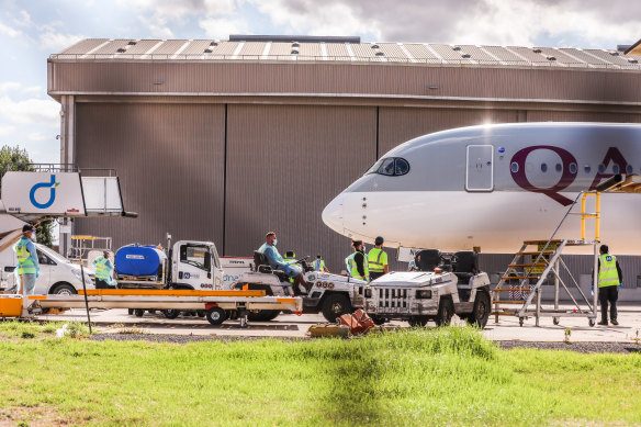 Biosecurity and airport staff in PPE gather around the chartered flight carrying tennis players and staff into Melbourne on Thursday.