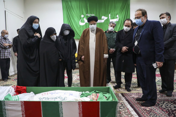 Iran's Judiciary Chief Ayatollah Ebrahim Raisi pays his respect to the body of slain scientist Mohsen Fakhrizadeh among his family, in Tehran, Iran, on Saturday.