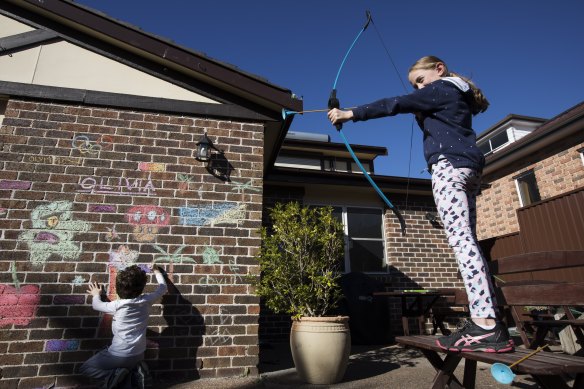 Siblings 12-year-old Olivia, right, and Lucas, 8, have been allowed to graffiti on the back of their house in Cumberland local government area during lockdown.