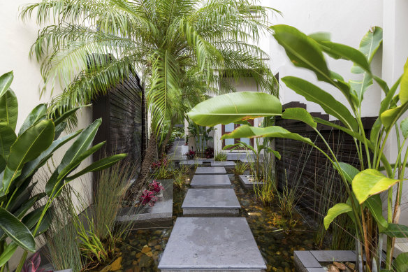 Tropical gardens and even waterfalls line the route to the front of the home.