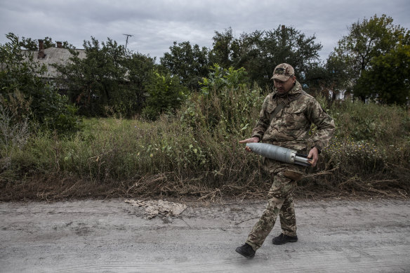 Ukraynalı bir asker, 11 Eylül'de kurtarılmış Zaliznychne köyünde bir tank mermisi taşıyor. 
