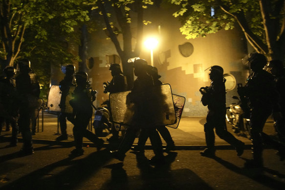 Police officers walk during a protest in Nanterre, outside Paris.