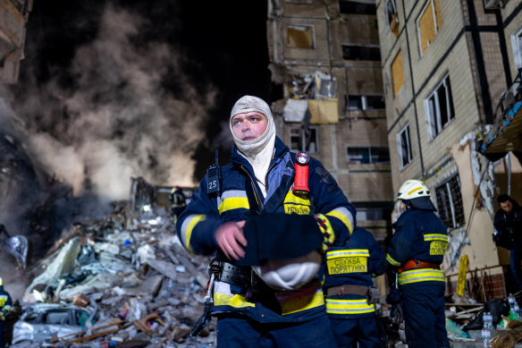 Emergency workers search the remains of a residential building that was struck by a Russian missile in Dnipro, Ukraine on Sunday.
