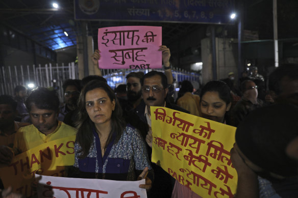 Indians outside Tihar central prison show their support for the execution of four men.