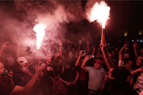 Protesters light flares in Beirut on Saturday night.