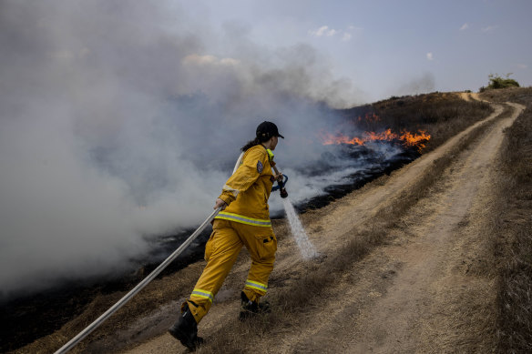 An Israeli firefighter attempts to extinguish a fire near Or HaNer Kibbutz, which Israel said was caused by a balloon launched from the Gaza Strip.
