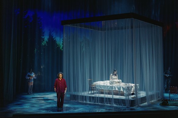 Natalie Jones, in red, plays Helen Garner, whose friend Nicola, inside the curtains, is dying.