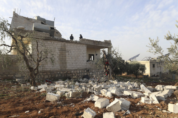 People check damage to a house in Atmeh on Thursday. The Pentagon said the military operation was a successful, large-scale counterterrorism raid. 