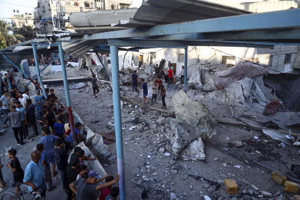 Palestinians look at the aftermath of the Israeli airstrike on a UN-run school. The attack killed at least 16 people in the Al-Nusseirat refugee camp in the Gaza Strip.