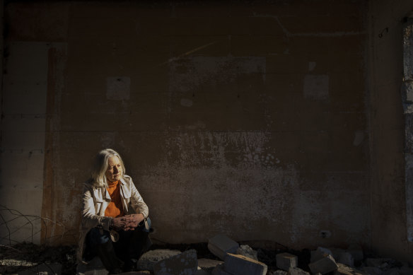 Jann Gilbert sits in the ruins of her Mallacoota home.