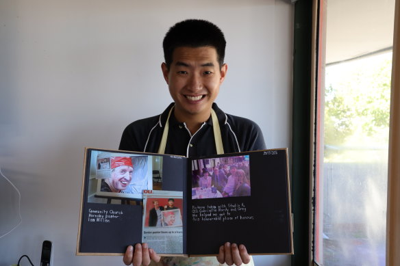 Daniel Kim with his scrapbook of memories of greg Warburton.