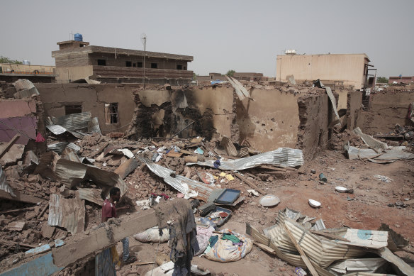 A man walks by a house hit in recent fighting in Khartoum.
