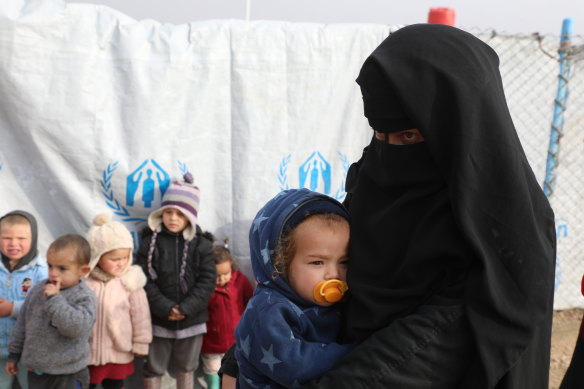 One of the Australian women in al-Hawl camp and a group of children.