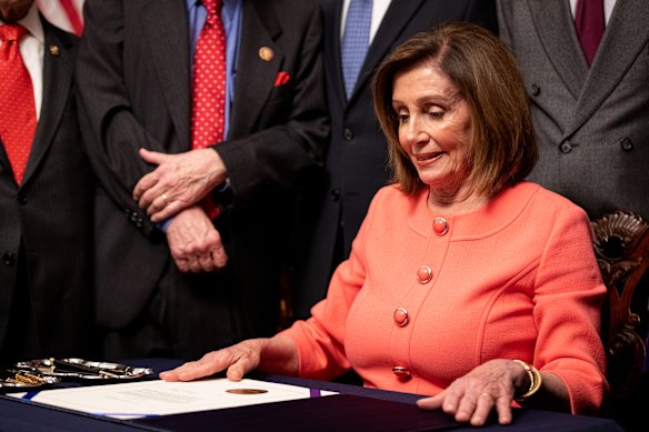 House Speaker Nancy Pelosi prepares to sign the official articles of impeachment.