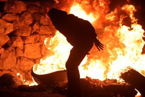 Palestinians burn tyres in response to Israeli strikes at a rally marking the 73rd anniversary of the Nakba Day.