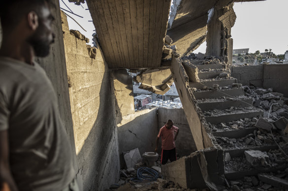 Palestinians inspect their homes after an Israeli airstrike in Gaza City on Sunday, August 7.