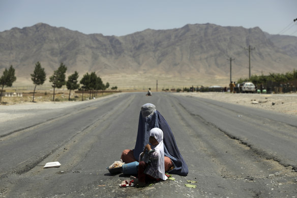 Afghanistan is falling into Taliban hands again. Here an Afghan woman begs for money on the Bagram-Kabul highway, north of Kabul.
