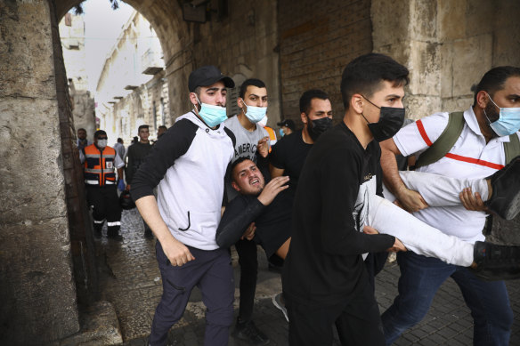 Palestinians evacuate a wounded protester during clashes with Israeli security forces at the Lions Gate in Jerusalem’s Old City on Monday.