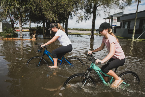 Locals cycle through floodwater in Ballina on Wednesday.