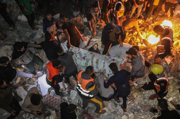 People inspect damage to their homes caused by Israeli air strikes on December in Rafah, Gaza. 