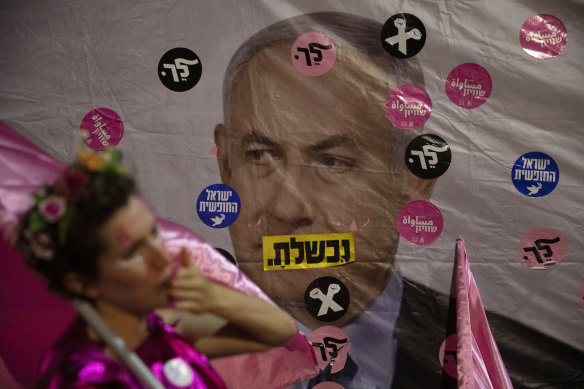 An Israeli protester wears pink during a demonstration against Israeli Prime Minister Benjamin Netanyahu outside his official residence in Jerusalem on Saturday, June 12, 2021. Hebrew reads: “You failed”,” Israel free” and “Leave”.