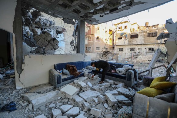 A person inspects their damaged home following Israeli air strikes in Rafah, Gaza. 