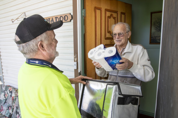 Meals on Wheels volunteer Al Wright delivers toilet paper to resident Bob Kerslake in 2020.