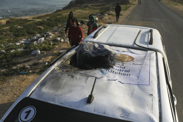 Palestinians inspect a vehicle with the logo of the World Central Kitchen wrecked by an Israeli airstrike in Deir al Balah, Gaza Strip,