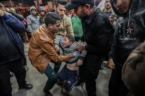 A young Palestinian injured in Israeli airstrikes arrives for treatment at Nasser Medical Hospital.